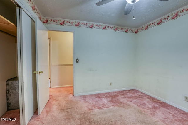 carpeted spare room featuring ceiling fan and a textured ceiling