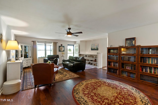 living room with dark hardwood / wood-style flooring and ceiling fan