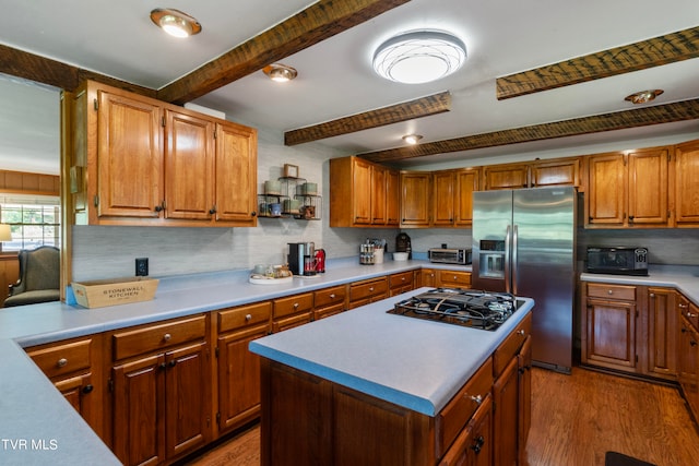 kitchen with a center island, beam ceiling, stainless steel appliances, and hardwood / wood-style floors