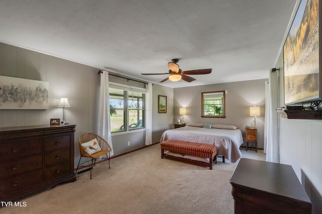 bedroom featuring ceiling fan, multiple windows, and light colored carpet