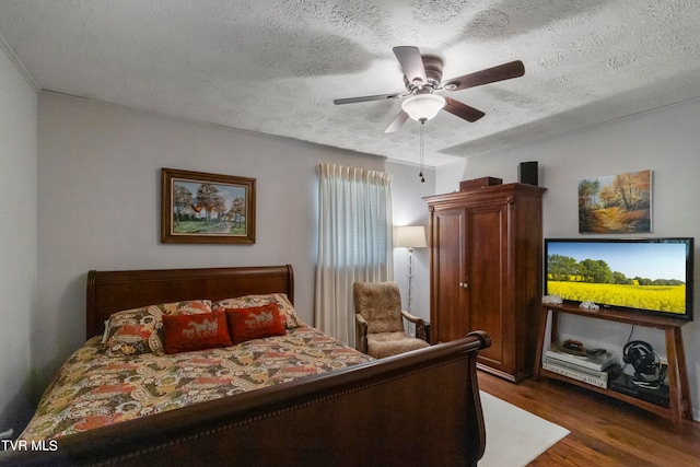 bedroom featuring a textured ceiling, dark wood-type flooring, and ceiling fan