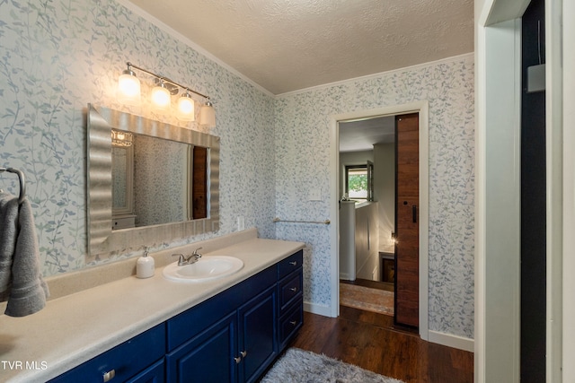 bathroom featuring crown molding, a textured ceiling, large vanity, and hardwood / wood-style floors