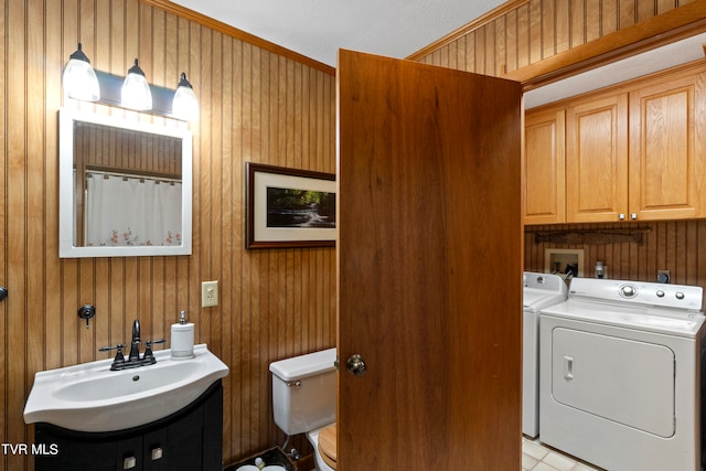 laundry area featuring washer and dryer, cabinets, washer hookup, wood walls, and sink