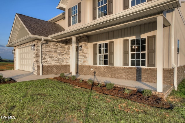 doorway to property featuring a lawn and a garage