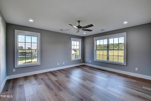 empty room featuring ceiling fan, a wealth of natural light, and light hardwood / wood-style flooring