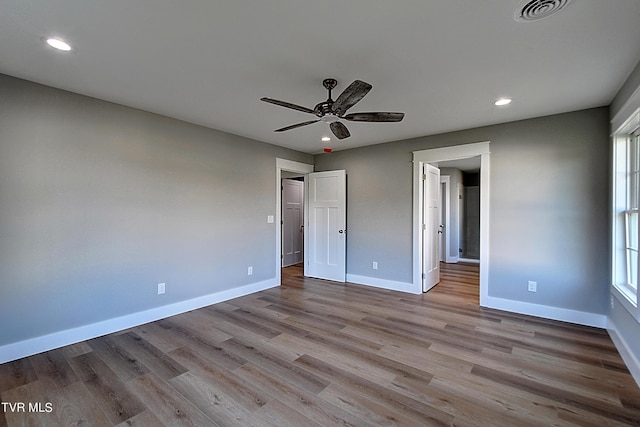 unfurnished bedroom with light hardwood / wood-style flooring, multiple windows, and ceiling fan