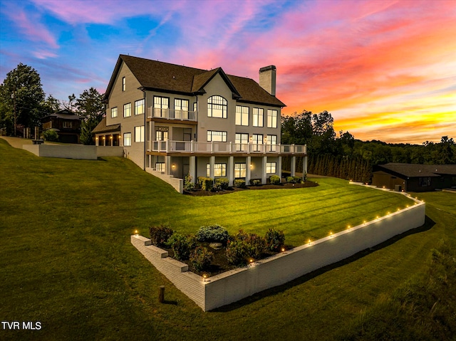 back house at dusk with a lawn