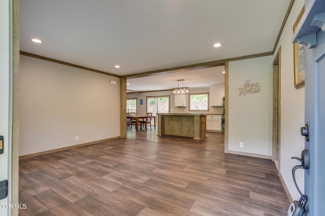 unfurnished living room with ornamental molding and dark hardwood / wood-style flooring