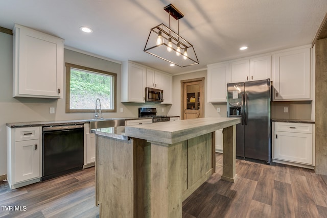 kitchen with white cabinets, dark wood-type flooring, a kitchen island, and appliances with stainless steel finishes