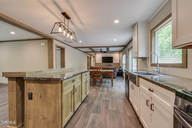 kitchen featuring ceiling fan, decorative light fixtures, dark wood-type flooring, a kitchen island, and sink