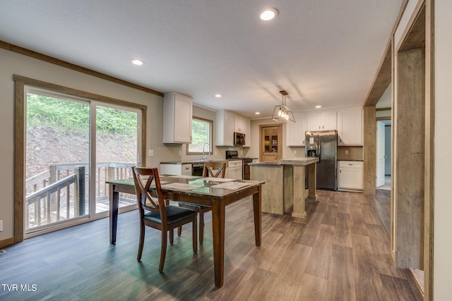 dining area featuring sink, crown molding, and wood-type flooring