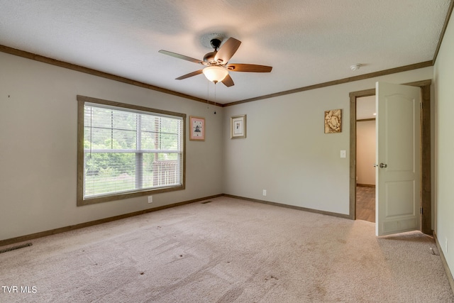 carpeted empty room featuring ceiling fan, a textured ceiling, and ornamental molding