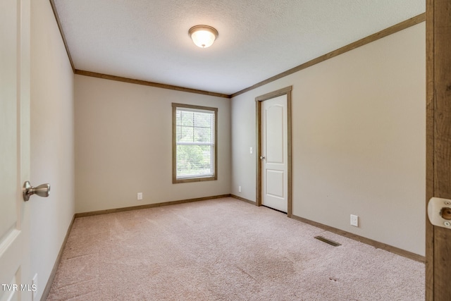 unfurnished room featuring light colored carpet, a textured ceiling, and crown molding