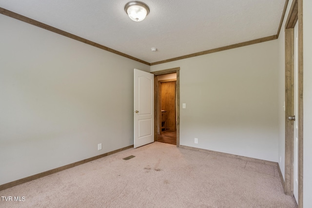 interior space featuring a textured ceiling, carpet floors, and crown molding