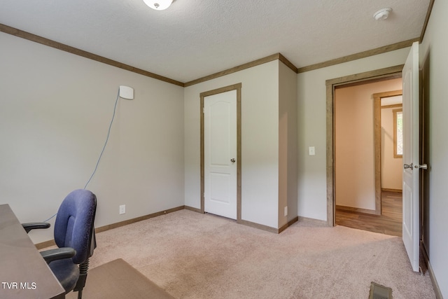 unfurnished office featuring ornamental molding, a textured ceiling, and light carpet