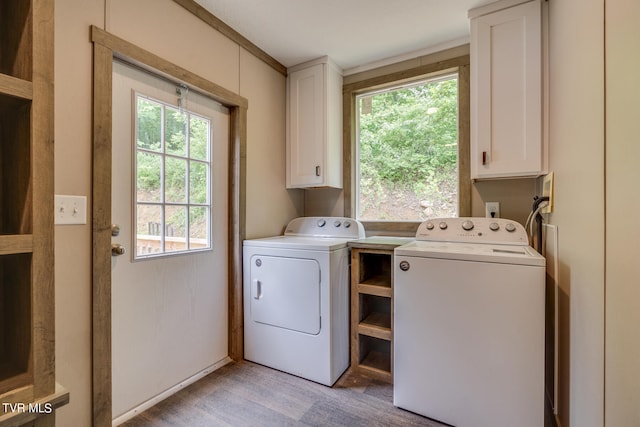 laundry room featuring a healthy amount of sunlight, separate washer and dryer, hookup for a washing machine, and cabinets