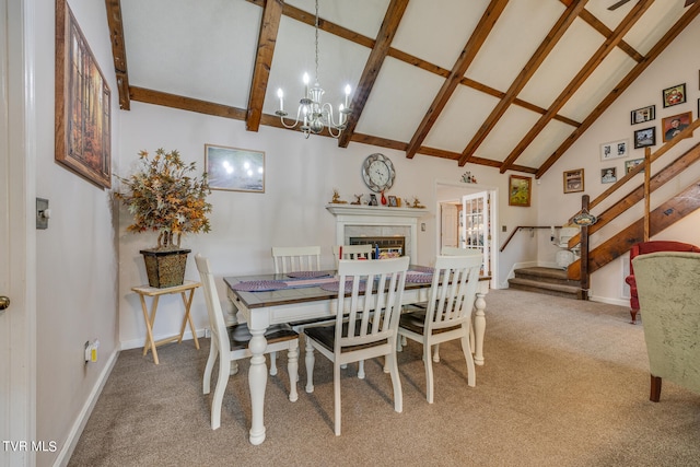 carpeted dining room with beamed ceiling, high vaulted ceiling, a premium fireplace, and a notable chandelier