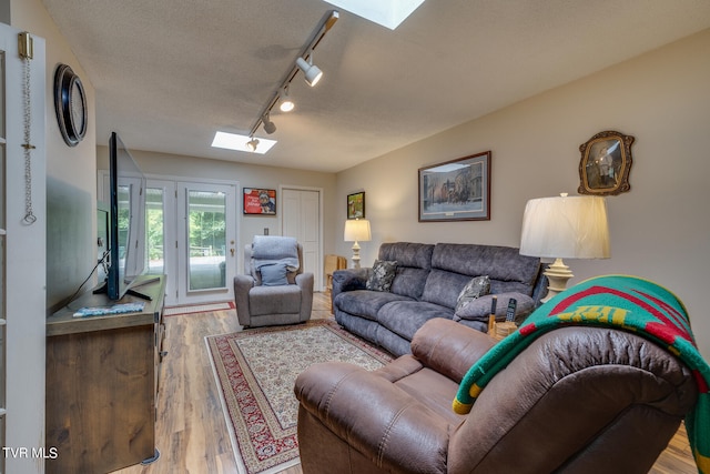 living room featuring a textured ceiling, a skylight, hardwood / wood-style flooring, and rail lighting