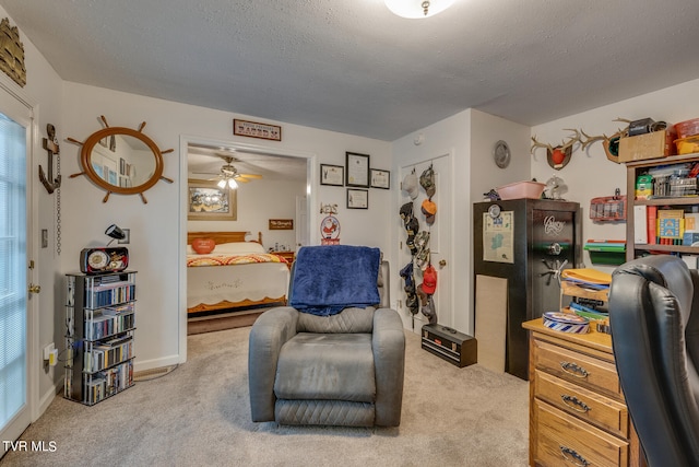 living area with light colored carpet, ceiling fan, and a textured ceiling