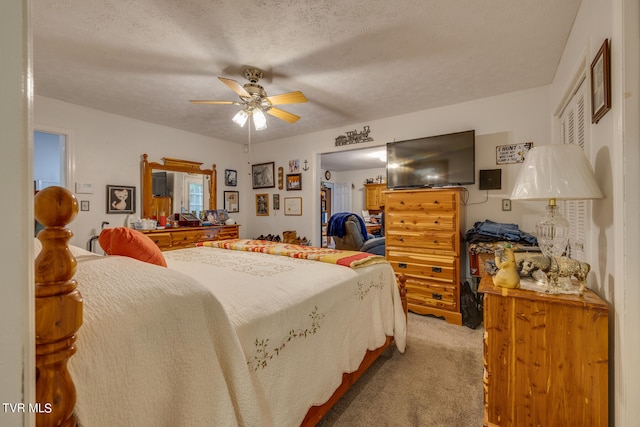 carpeted bedroom with ceiling fan and a textured ceiling