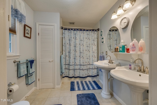 bathroom with tile flooring and a textured ceiling