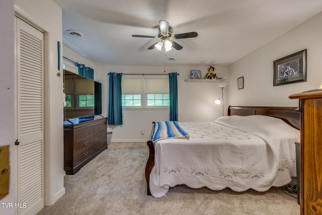 carpeted bedroom with ceiling fan and a closet