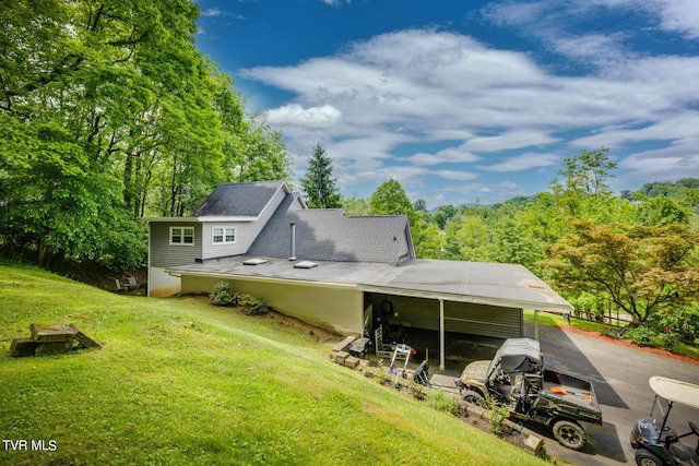 rear view of property with a carport and a lawn