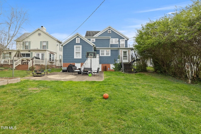 back of property with a wooden deck, a lawn, and a patio