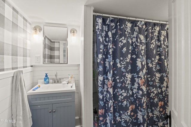 bathroom with tile walls and vanity with extensive cabinet space