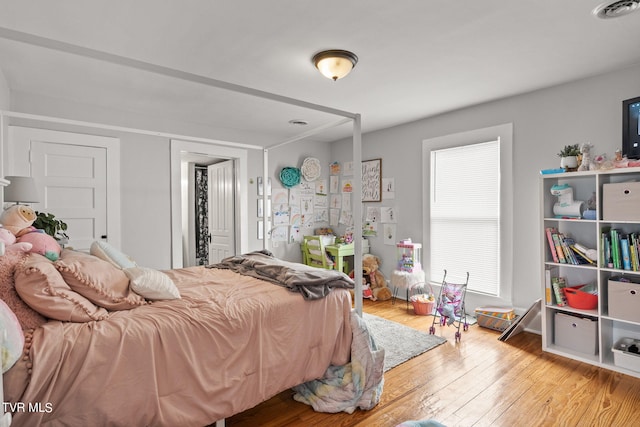 bedroom with multiple windows and light hardwood / wood-style floors