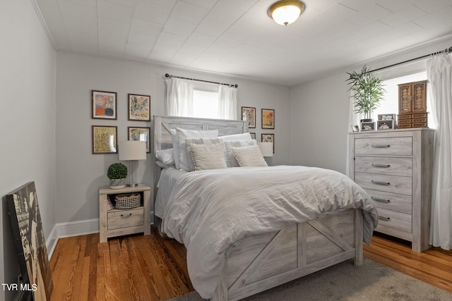 bedroom with dark hardwood / wood-style floors and crown molding