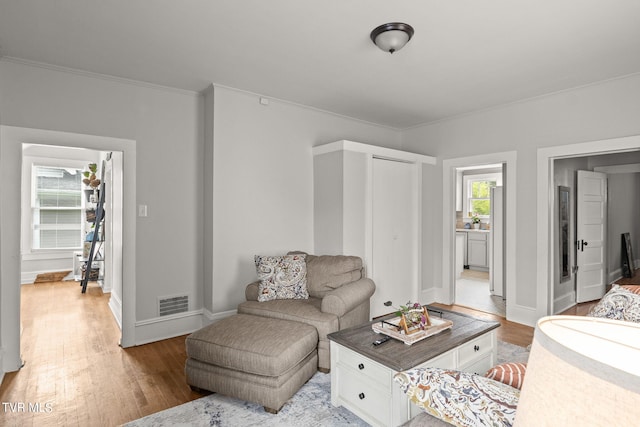 living room featuring crown molding and hardwood / wood-style flooring