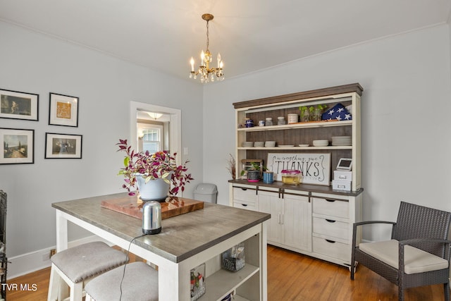 interior space featuring an inviting chandelier, ornamental molding, and light hardwood / wood-style floors