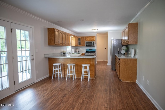 1466 Broad St, Elizabethton, TN 37643 - kitchen with brown cabinetry, a peninsula, dark wood-style flooring, stainless steel appliances, and crown molding