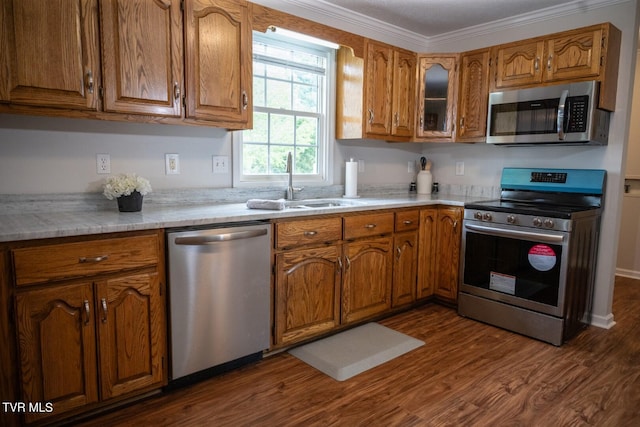 1466 Broad St, Elizabethton, TN 37643 - kitchen featuring crown molding, dark wood finished floors, light countertops, brown cabinets, and appliances with stainless steel finishes