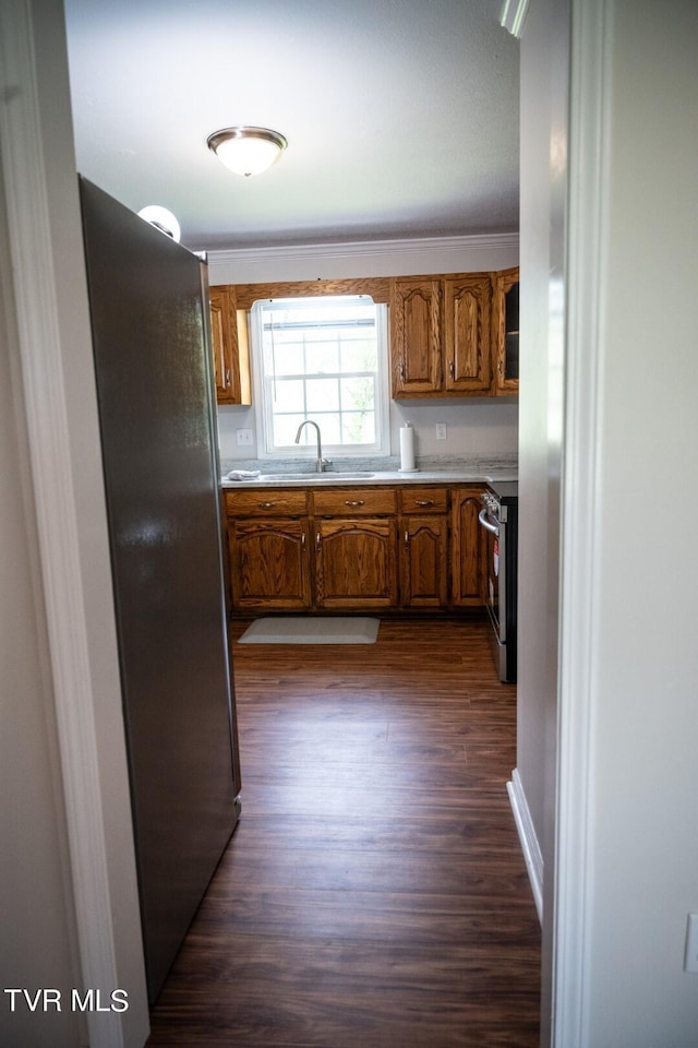 1466 Broad St, Elizabethton, TN 37643 - kitchen with a sink, stainless steel appliances, brown cabinetry, light countertops, and dark wood-style flooring