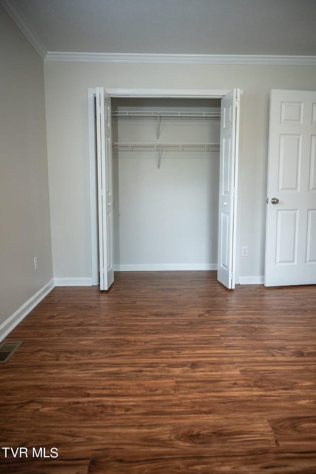 1466 Broad St, Elizabethton, TN 37643 - unfurnished bedroom featuring a closet, dark wood-style flooring, and crown molding