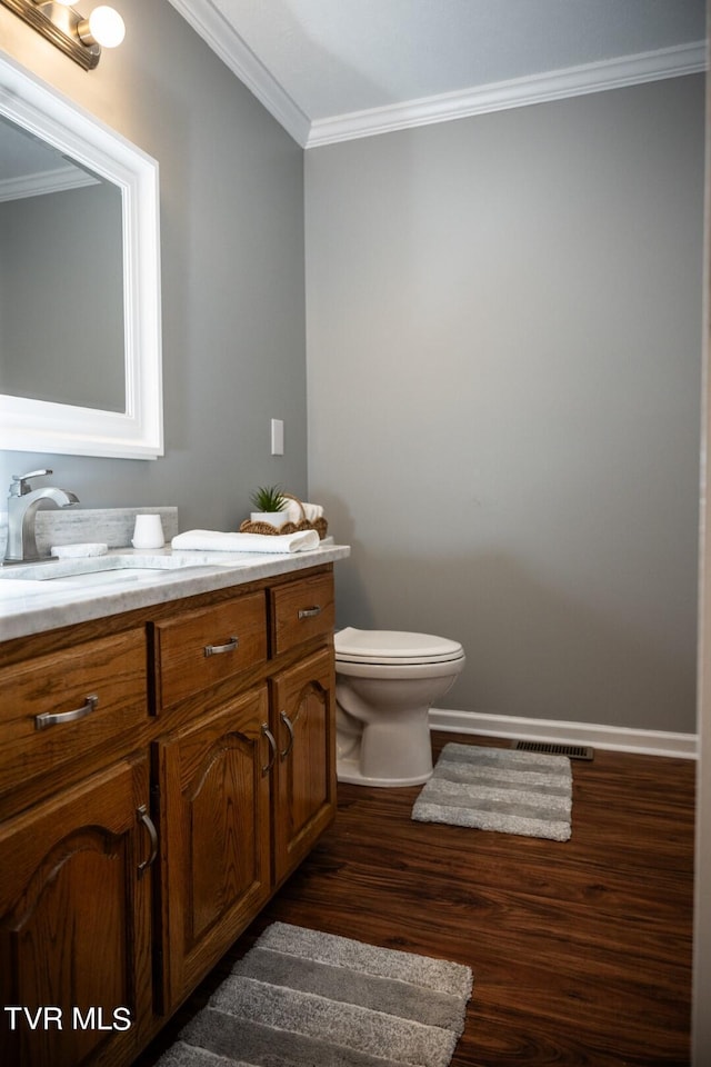 1466 Broad St, Elizabethton, TN 37643 - half bath featuring vanity, wood finished floors, visible vents, crown molding, and toilet