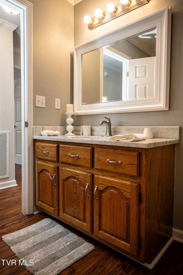 1466 Broad St, Elizabethton, TN 37643 - bathroom with wood finished floors, visible vents, double vanity, a sink, and crown molding