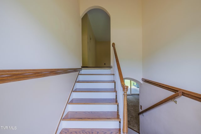 staircase featuring a towering ceiling