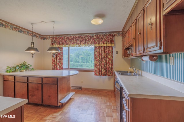 kitchen featuring sink, decorative light fixtures, light parquet flooring, and a textured ceiling