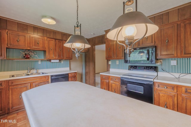 kitchen with hanging light fixtures, light parquet flooring, sink, and black appliances