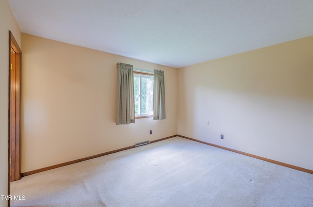 spare room featuring light colored carpet