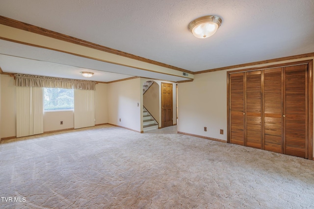 basement with light carpet, crown molding, and a textured ceiling