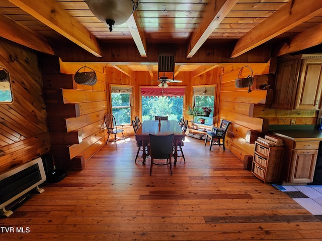 dining room with heating unit, wooden ceiling, wooden walls, hardwood / wood-style flooring, and beam ceiling