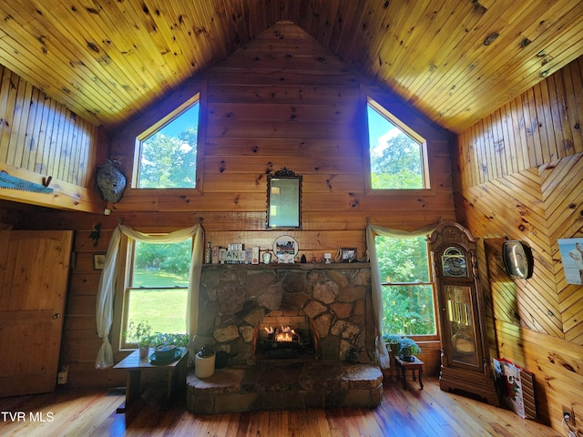 living room featuring wood-type flooring, wooden walls, and high vaulted ceiling