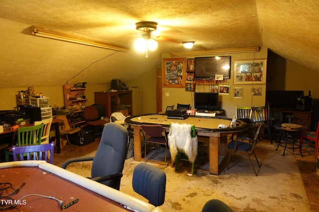 interior space featuring vaulted ceiling, ceiling fan, and a textured ceiling