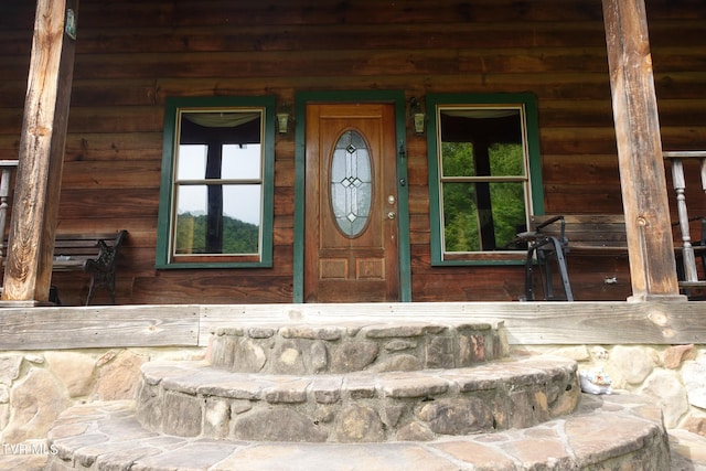 view of exterior entry featuring covered porch