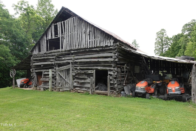 rear view of property featuring an outdoor structure and a yard