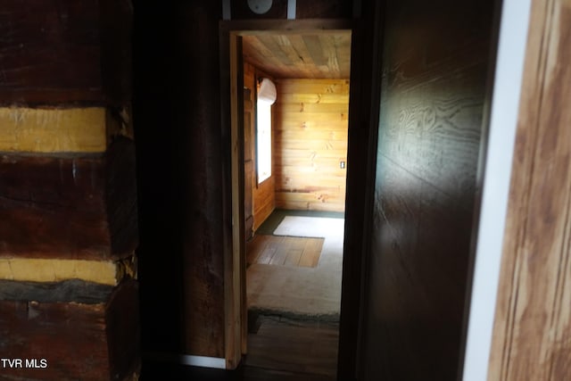 hallway featuring wooden walls